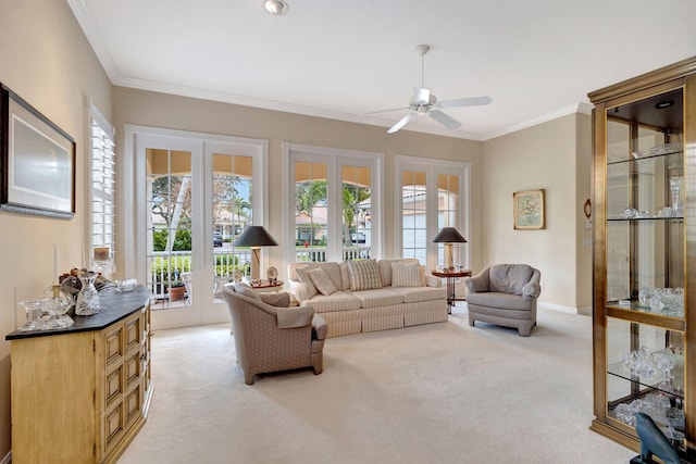 living room featuring french doors, ceiling fan, ornamental molding, and light carpet