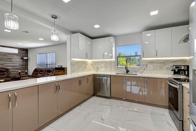 kitchen with sink, appliances with stainless steel finishes, white cabinetry, tasteful backsplash, and decorative light fixtures