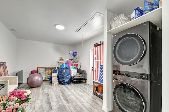 laundry area with stacked washer / drying machine and hardwood / wood-style flooring