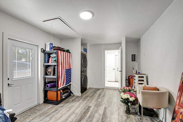 miscellaneous room with hardwood / wood-style floors and stacked washer / dryer