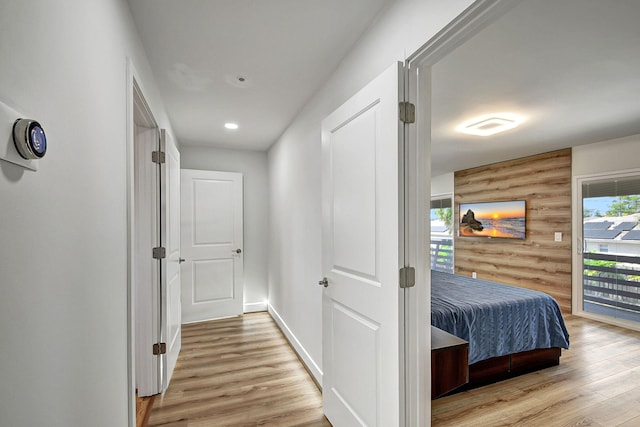 hallway with wooden walls and light wood-type flooring