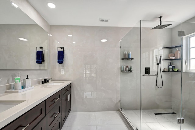 bathroom with walk in shower, tile patterned floors, vanity, and tile walls