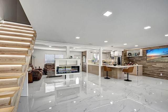 kitchen with pendant lighting, a breakfast bar, stainless steel refrigerator, a center island, and a wealth of natural light