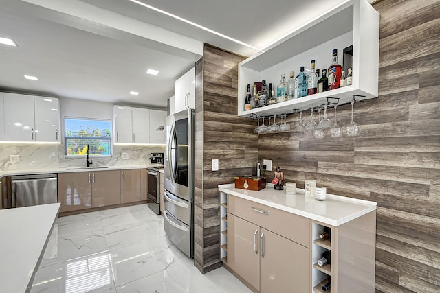 kitchen featuring white cabinetry, sink, tasteful backsplash, and stainless steel appliances