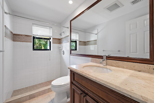 bathroom featuring tiled shower, vanity, toilet, and tile patterned floors