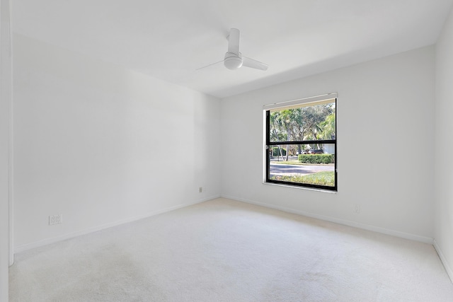 empty room featuring ceiling fan and light carpet