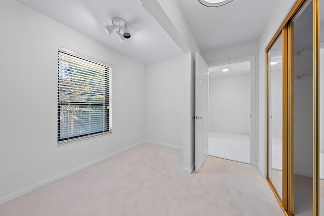 unfurnished bedroom with light carpet and a closet