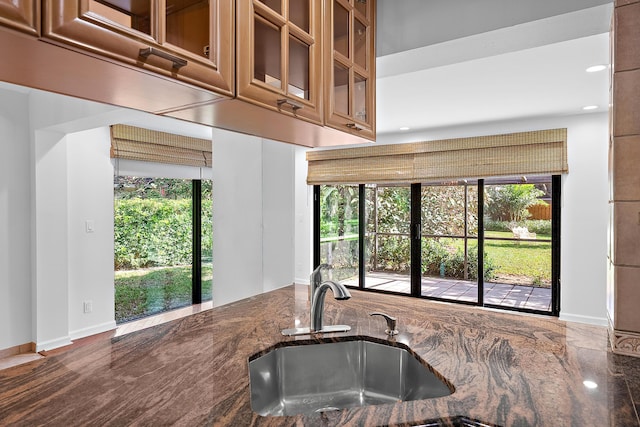 kitchen with sink, plenty of natural light, and dark stone counters