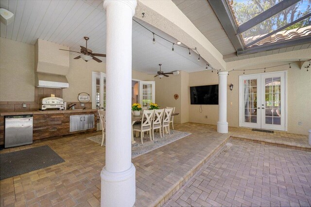 unfurnished sunroom featuring ornate columns, an inviting chandelier, and french doors