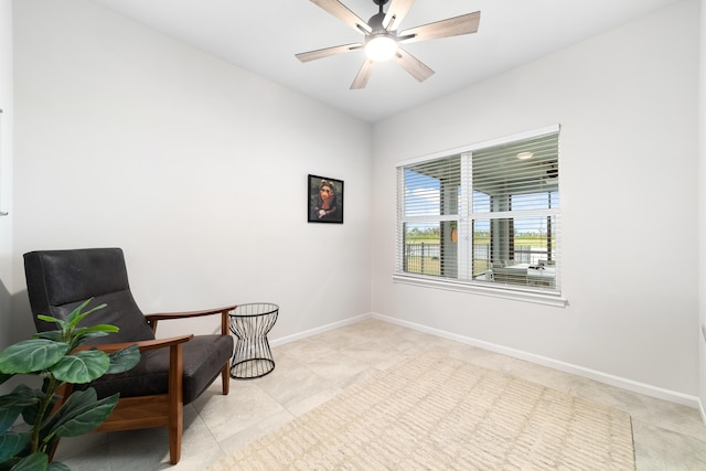 living area with light tile patterned floors and ceiling fan