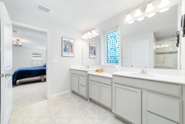 bathroom with a healthy amount of sunlight, vanity, tile patterned flooring, and a shower with door