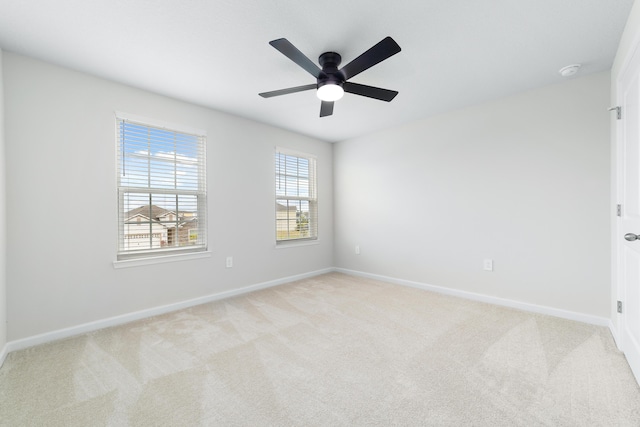 carpeted spare room featuring ceiling fan