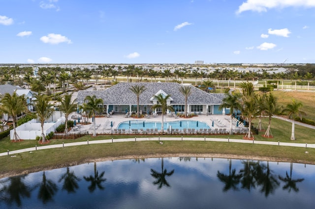 back of house with a water view, a community pool, a patio, and a lawn