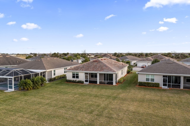 rear view of property with a yard and a sunroom