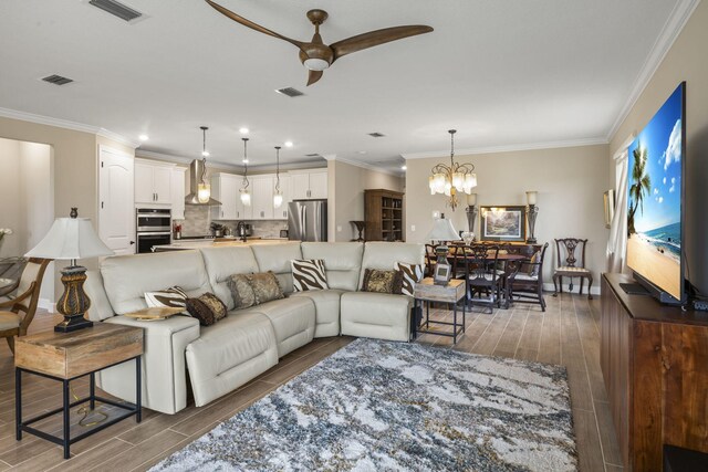 dining area with ornamental molding, a chandelier, and light hardwood / wood-style flooring