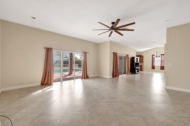 unfurnished living room featuring lofted ceiling, ceiling fan with notable chandelier, and light tile patterned flooring