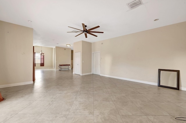 unfurnished room featuring ceiling fan with notable chandelier and light tile patterned floors