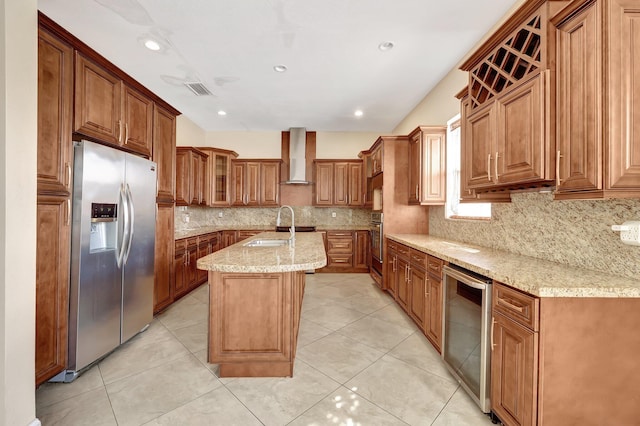 kitchen featuring appliances with stainless steel finishes, beverage cooler, a kitchen island with sink, light stone countertops, and wall chimney exhaust hood