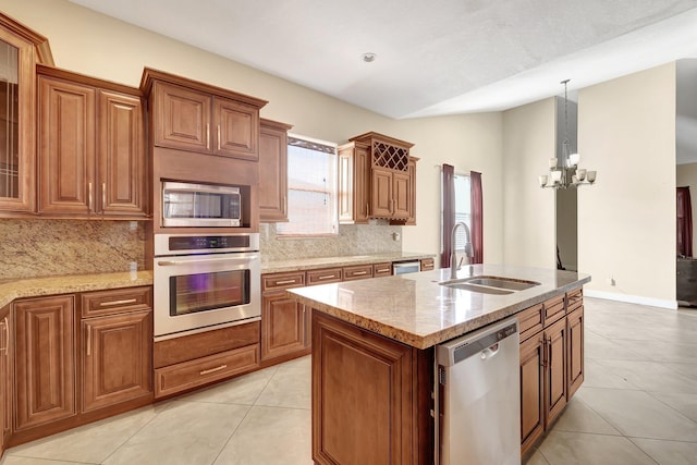 kitchen with sink, hanging light fixtures, a kitchen island with sink, stainless steel appliances, and an inviting chandelier