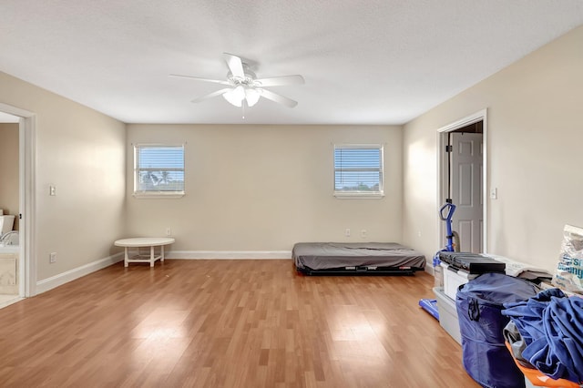 interior space with ceiling fan, a textured ceiling, and light hardwood / wood-style flooring