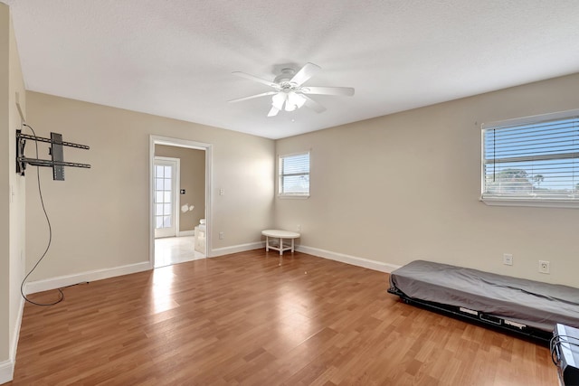 interior space with ceiling fan, hardwood / wood-style flooring, and a textured ceiling