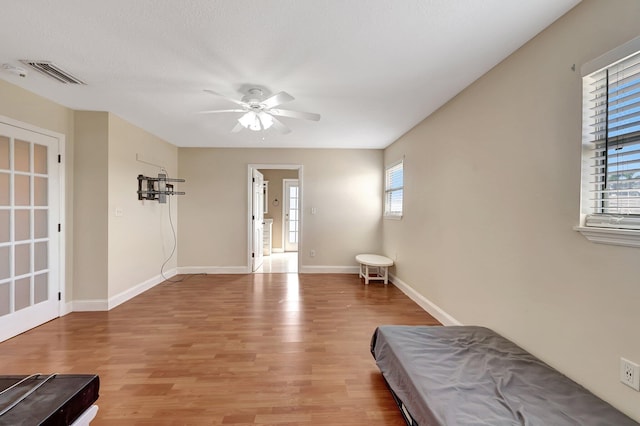 interior space featuring ceiling fan, wood-type flooring, and a textured ceiling