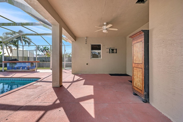 view of patio / terrace with a fenced in pool, ceiling fan, and glass enclosure