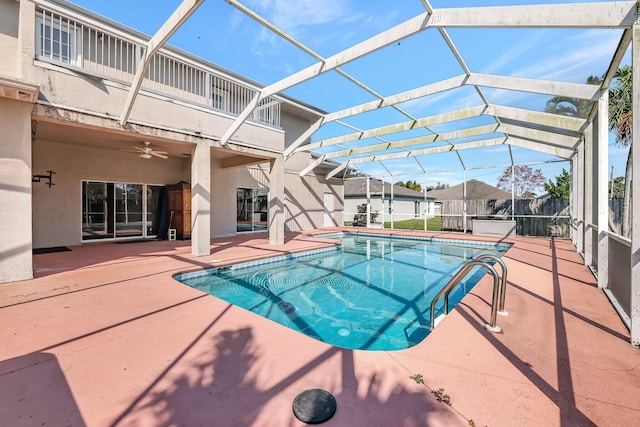 view of swimming pool with a jacuzzi, a patio, ceiling fan, and glass enclosure