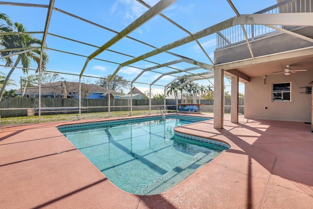 view of swimming pool featuring ceiling fan, a patio area, and glass enclosure