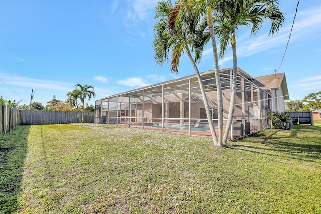 back of property featuring a fenced in pool, a yard, and glass enclosure