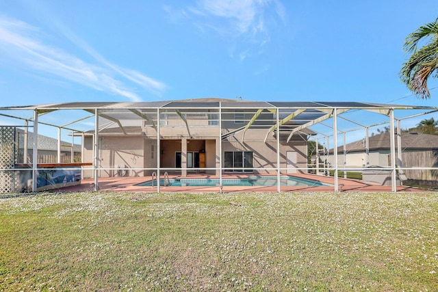 rear view of property featuring a patio, a lanai, and a lawn