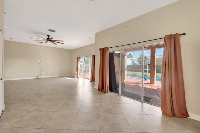 empty room with ceiling fan and light tile patterned floors