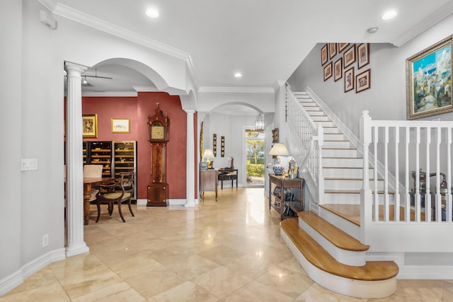 foyer entrance with decorative columns and ornamental molding