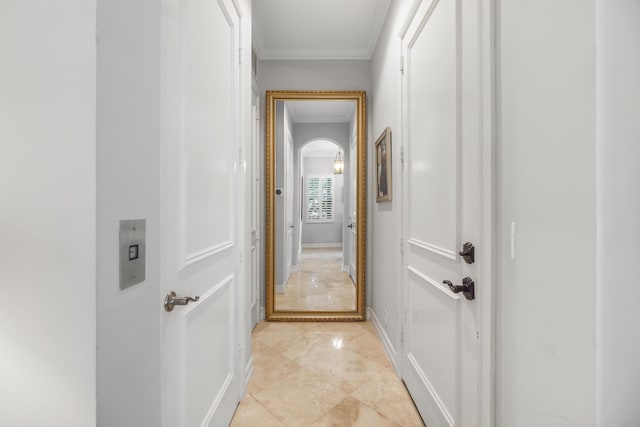 hallway featuring ornamental molding and light tile patterned flooring