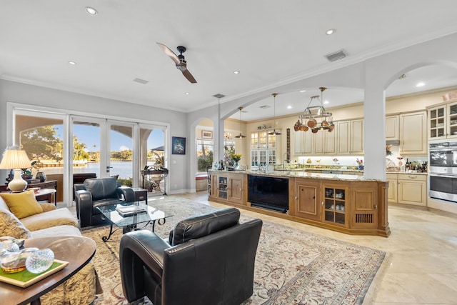 living room with a water view, ceiling fan, ornamental molding, and french doors