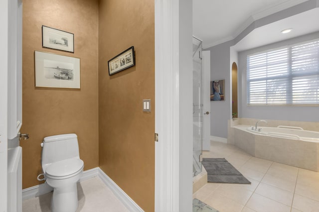 bathroom with tile patterned flooring, ornamental molding, a washtub, and toilet