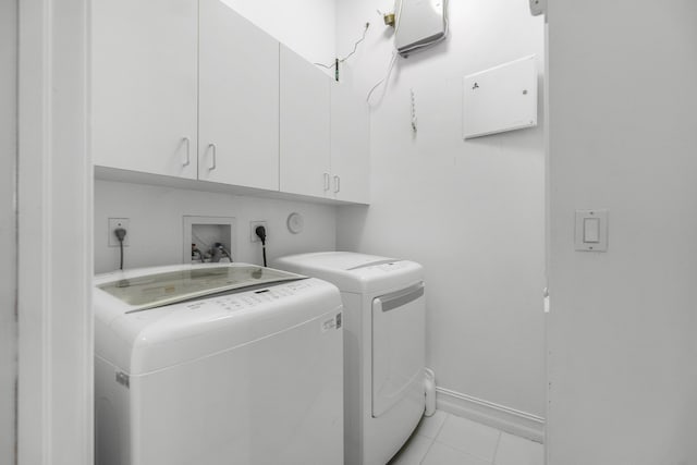 washroom with cabinets, washer and dryer, and light tile patterned floors