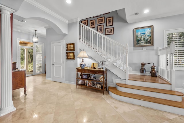 stairway featuring crown molding and decorative columns