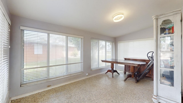 home office featuring vaulted ceiling, light speckled floor, and baseboards