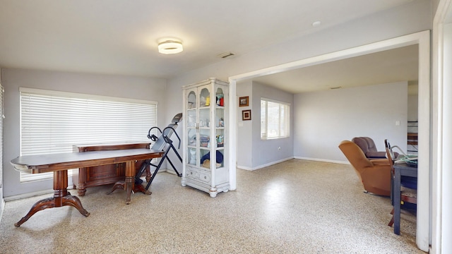 office space with baseboards and speckled floor