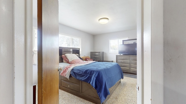 bedroom featuring speckled floor and multiple windows