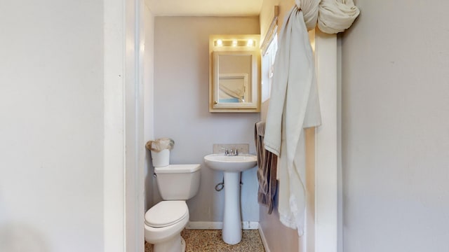 bathroom with speckled floor, baseboards, and toilet