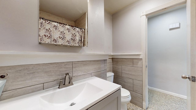 bathroom featuring speckled floor, toilet, vanity, and baseboards