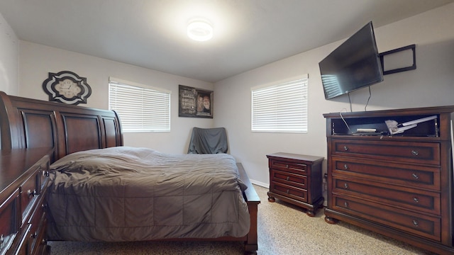 bedroom featuring baseboards and multiple windows