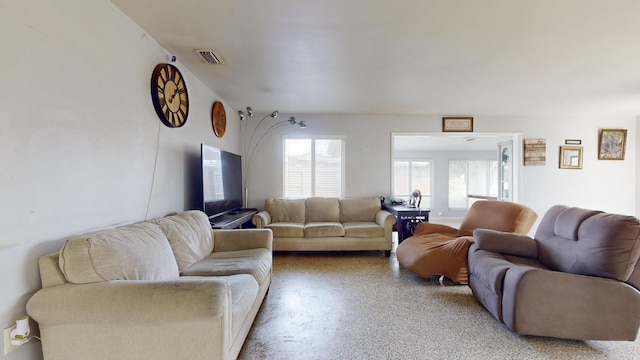 living area featuring light speckled floor and visible vents
