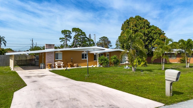 ranch-style home with a front lawn, an attached carport, a chimney, concrete driveway, and stucco siding