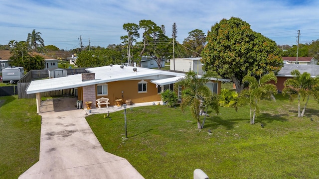 view of front of property featuring a carport, a front lawn, driveway, and stucco siding