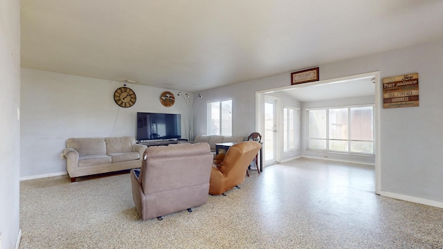 living room featuring baseboards and speckled floor