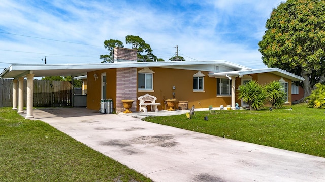 view of front of house featuring concrete driveway, a front lawn, an attached carport, and stucco siding