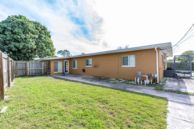 rear view of property featuring a yard and a patio